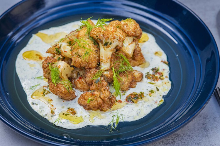 Cooked cauliflower on a plate with garnish