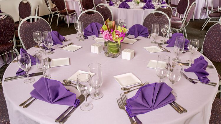 A banquet table setup with purple decor