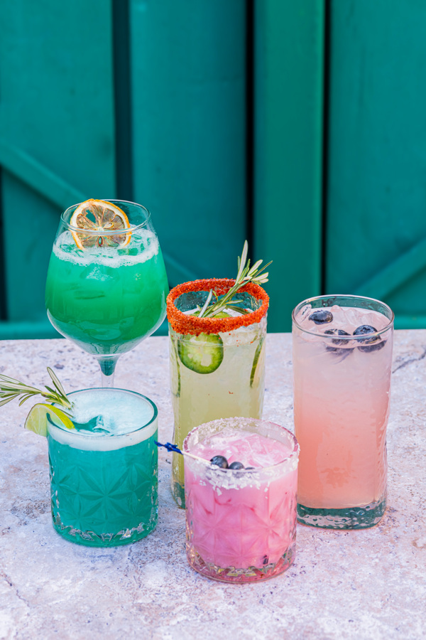 five colorful drinks on a table