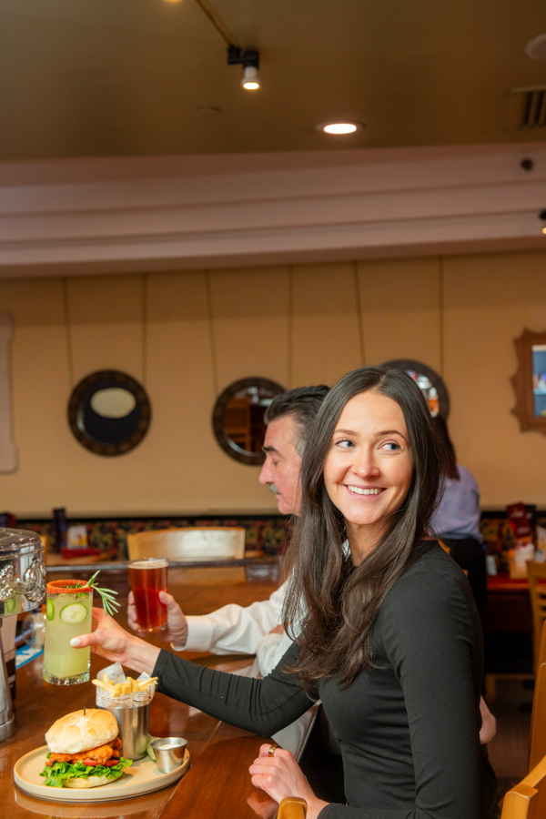 A couple enjoying drinks and food at a bar with a warm atmosphere.