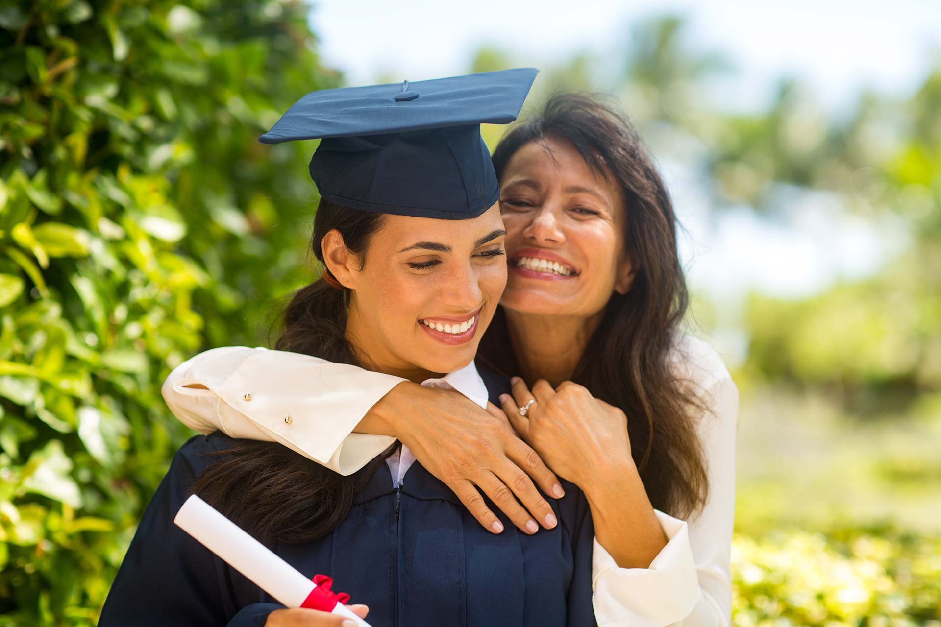 A female graduate being hugged by her mom